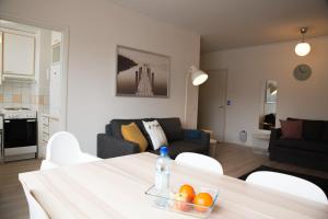 a living room with a table with a bowl of oranges on it at Borent Suite Family in Turku
