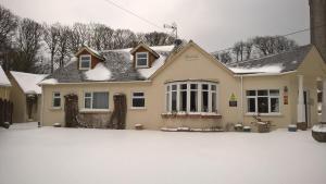 a house with snow on the ground at Rosedene Guest House in Pembroke