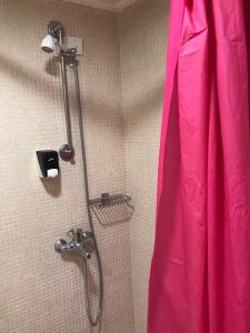 a shower with a pink dress in a bathroom at Captain Yiannis Studios & Apartments in Kos