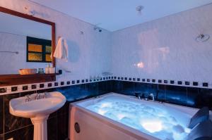 a bathroom with a tub, sink, and bathtub at Hotel Antonio Nariño in Villa de Leyva
