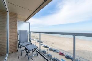 a chair on a balcony with a view of the beach at Apartment Sea View in Middelkerke