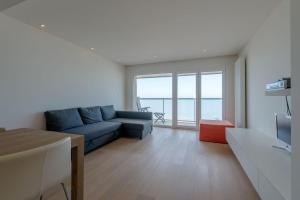 a living room with a blue couch and a table at Apartment Sea View in Middelkerke