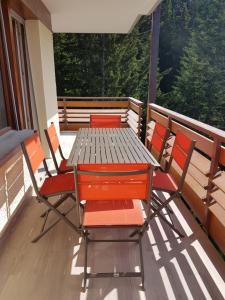 een houten tafel en stoelen op een balkon bij Télérésidence in Crans-Montana