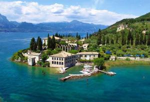 een eiland in het midden van een groot waterlichaam bij Welcome Traveller LA PERLA APARTMENTS in Garda