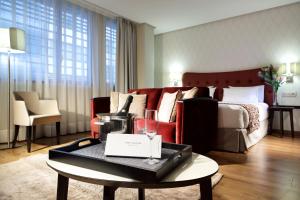 Pokój hotelowy z łóżkiem i stołem z kieliszkiem wina w obiekcie Eurostars Plaza Mayor w Madrycie