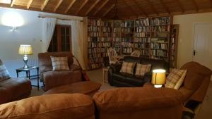 ein Wohnzimmer mit Sofas und Bücherregalen in der Unterkunft The Old Cottage in Arduaine