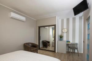 1 dormitorio con cama, escritorio y espejo en Il Guscio, en Bitritto
