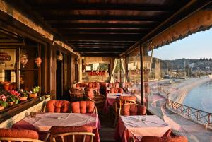 a restaurant with tables and chairs on a balcony at Maistrali Hotel in Afissos