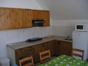 a kitchen with wooden cabinets and a white refrigerator at Apartman Svoboda in Svoboda nad Úpou