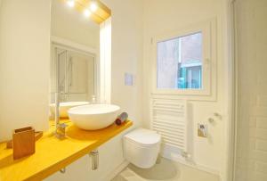 bagno bianco con lavandino e servizi igienici di DolceVita Apartments N 396 a Venezia