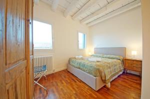 um quarto com uma cama, uma secretária e uma janela em DolceVita Apartments N 396 em Veneza