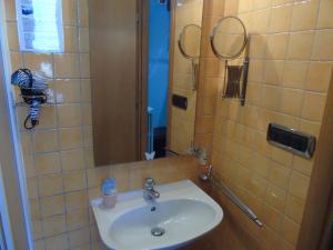 bagno con lavandino e specchio di Hotel Rainbow ad Arma di Taggia