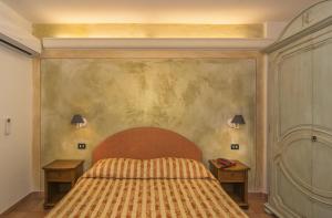 サンタ・マリア・デル・ジューディチェにあるHotel Ristorante da Carlosのベッドルーム1室(ベッド1台、ナイトスタンド2台付)