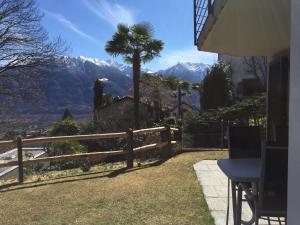 a house with a fence and a palm tree and mountains at Green View Apartments in Contra