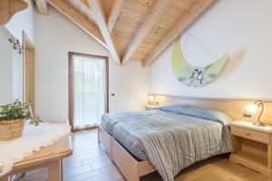 ein Schlafzimmer mit einem Bett in einem Zimmer mit Holzdecken in der Unterkunft Agritur Maso Rauter in Vattaro