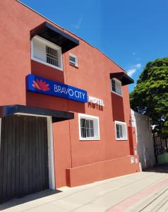 a red building with a blue sign on it at Bravo City Hotel Campo Grande in Campo Grande