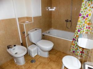 a bathroom with a toilet and a sink and a tub at Hotel Royal in Ronda
