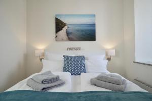 a bedroom with a bed with towels on it at MyHome Ruegen - Haus Arkona in Ostseebad Sellin