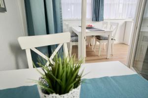 comedor con mesa blanca y sillas blancas en MyHome Ruegen - Haus Arkona, en Ostseebad Sellin