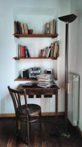a desk with a chair and a lamp and books at Casa Argo in antico borgo medievale in Borgo a Buggiano