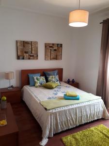 - une chambre avec un lit et des oreillers dans l'établissement Nazaré Villa North Wave, à Nazaré