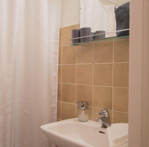 a bathroom with a sink and a shower curtain at Borent Suite Apartment in Turku