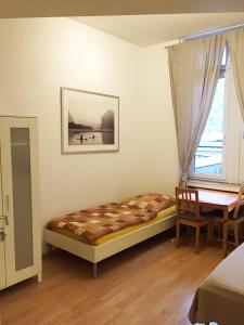 ハノーファーにあるHannover Südstadt - Zimmer und Apartmentのベッドルーム1室(ベッド1台、テーブル、窓付)