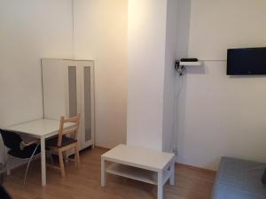 um quarto com uma mesa, uma mesa e uma cadeira em Hannover Südstadt - Zimmer und Apartment em Hanôver