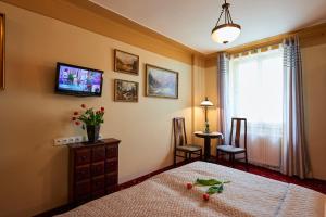 a bedroom with a bed and a tv on the wall at Hotel Stará Pekárna s privátním wellness in Liberec