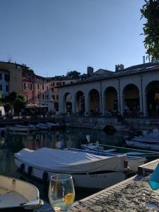 a glass of wine sitting on a dock with boats in the water at Palazzina Gelsomino in Desenzano del Garda