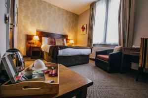 a hotel room with a bed and a couch at The Duke of Edinburgh Hotel & Bar in Barrow in Furness +55 photos