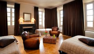 ein Wohnzimmer mit 2 Betten und einem Kamin in der Unterkunft Domaine de Carrière in Marvejols