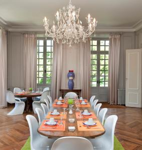 ein Esszimmer mit einem langen Tisch und weißen Stühlen in der Unterkunft Domaine de Carrière in Marvejols