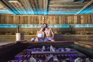 Ein Mann und eine Frau sitzen in einer Badewanne und telefonieren. in der Unterkunft Hotel Kronblick in Kiens + 88 Fotos