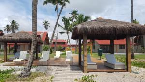 嘎林海斯港的住宿－Oka Beach Residence，海滩上的一组椅子和遮阳伞