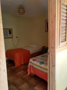 a small room with two beds and a window at Hotel Loro Tuerto in Santa Cruz de Barahona