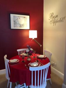 a red dining room table with a red tablecloth and white chairs at Hamish's Hame Edinburgh Licence No EH 69774 P in Edinburgh