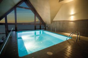 a large swimming pool in a building with a large window at Hotel Cumbres Puerto Varas in Puerto Varas