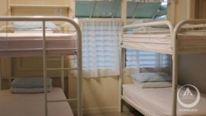 a room with three bunk beds in a dorm at Hostel Honolulu in Honolulu