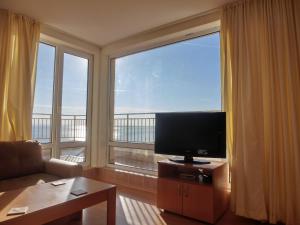 a living room with a television and a large window at Panoramic Sea View Apartment Crown, Pools and Beach, Sveti Vlas in Sveti Vlas