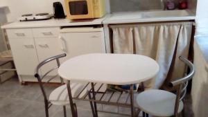ソスペルにあるApartment Des Romainsのキッチン(椅子2脚、白いテーブル、電子レンジ付)