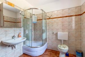 a bathroom with a shower and a toilet and a sink at Apartmani Villa Casper in Veli Lošinj