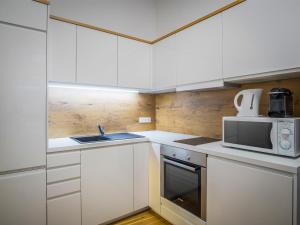 a white kitchen with a sink and a microwave at SKY9 Apartments City Center in Vienna