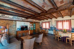 una sala de estar con techos de madera, mesas y sillas en Hotel Rural Almazara, en Frigiliana
