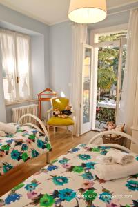 梅納焦的住宿－Casa Azzurra，一间卧室配有两张床和一张黄色椅子