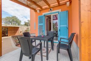 a patio with a table and chairs on a house at Apartmani Villa Casper in Veli Lošinj