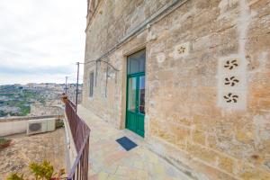 a building with a green door and a balcony at Dimora Santa Barbara in Matera