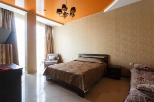 1 dormitorio con 1 cama y 1 silla en Hotel Orange, en Yessentuki