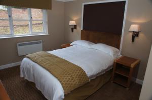 a bedroom with a large bed and two windows at Narrowboat at Weedon in Weedon Bec