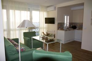 a living room with green chairs and a table at Infanta Beatriz in Sanlúcar de Barrameda